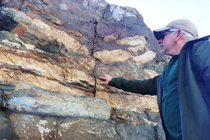 Christopher Hollis points to ancient sediments in New Zealand