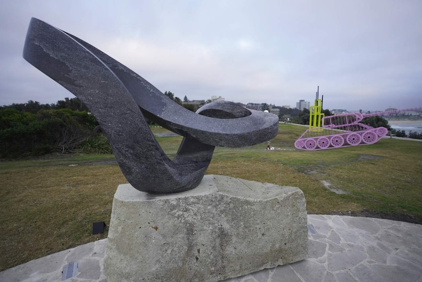 A grey sculpture on the coastline at Bondi.