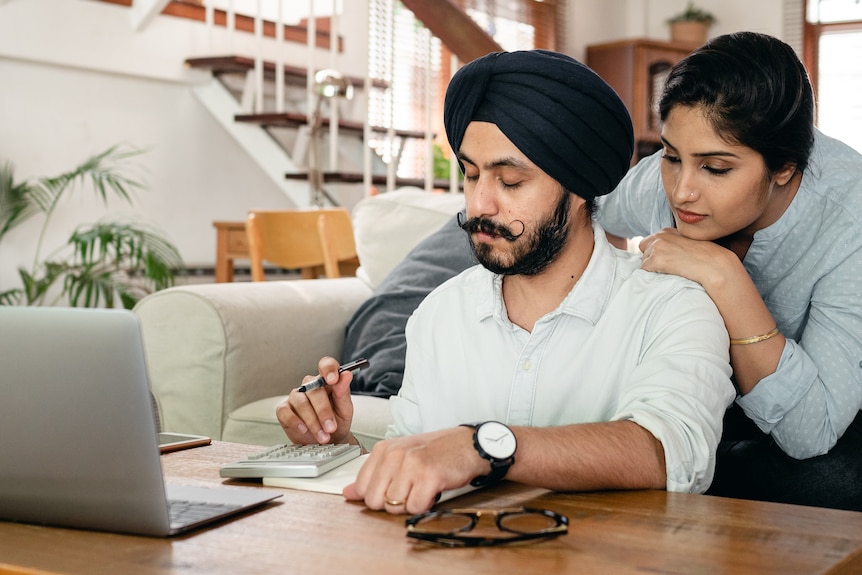 A woman watches on as her partner continues working. 