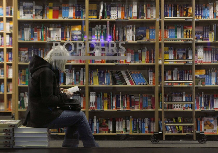 A customer is seen through the window of a Borders book store in New York.