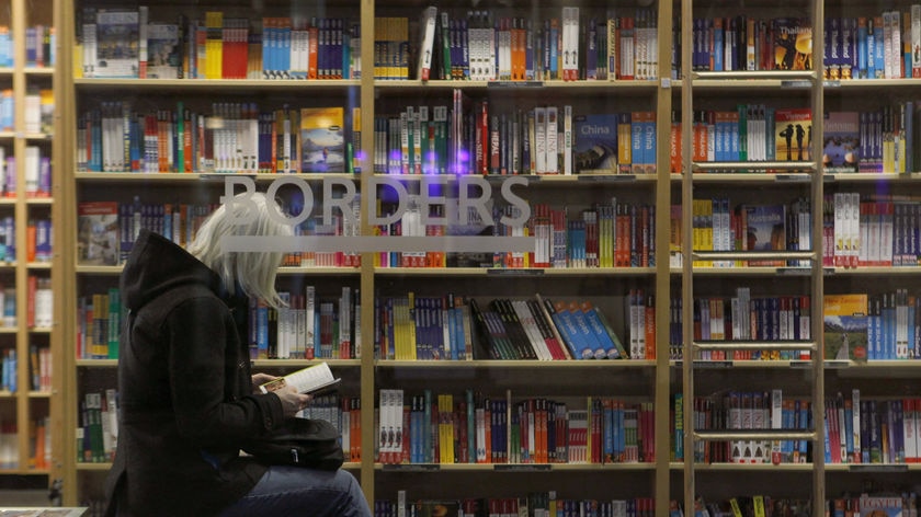 A customer is seen through the window of a Borders book store in New York.