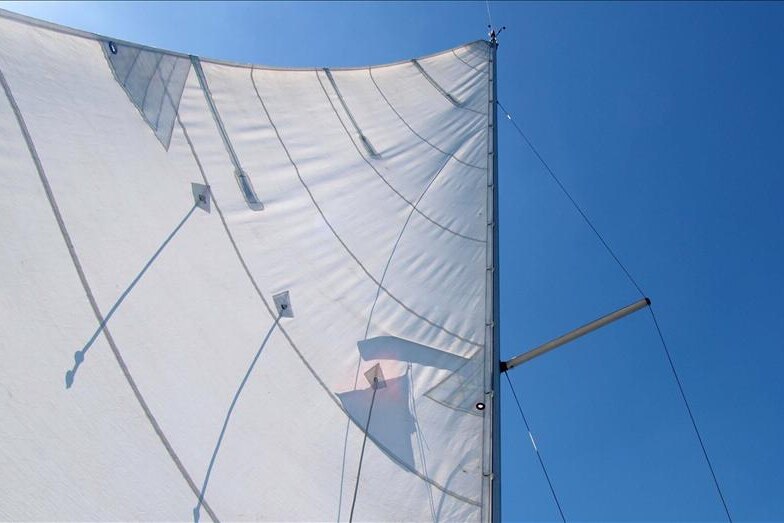 A yacht's sail billows in the wind