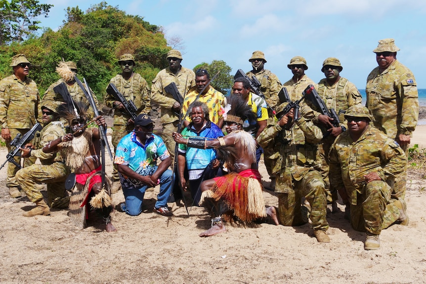 A group of Islander Australian Defence Force personal pose for photo with dancers and locals