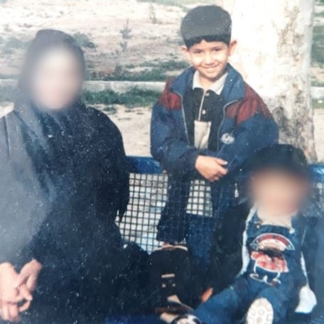 A woman and her two young sons. Her face and the youngest child's face are blurred.