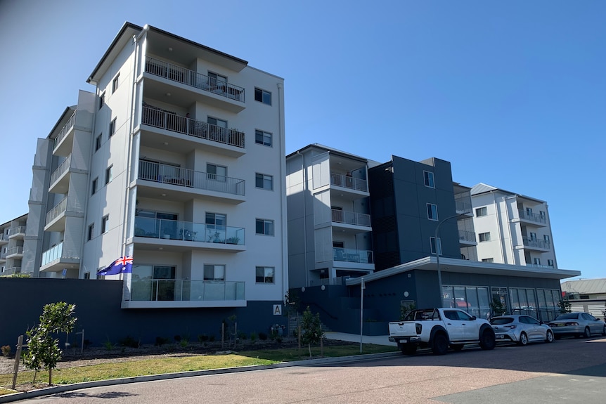 An exterior picture of a several storey apartment block