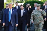 Mark Milley can be seen on the far right in camouflage fatigues walking as part of Mr Trump's entourage towards the church.