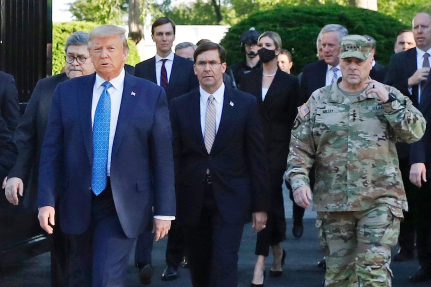 Mark Milley can be seen on the far right in camouflage fatigues walking as part of Mr Trump's entourage towards the church.