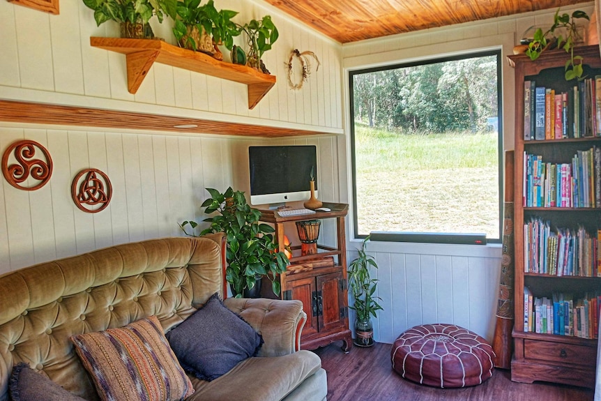 couch and bookshelf inside loungeroom of tiny home on rural land