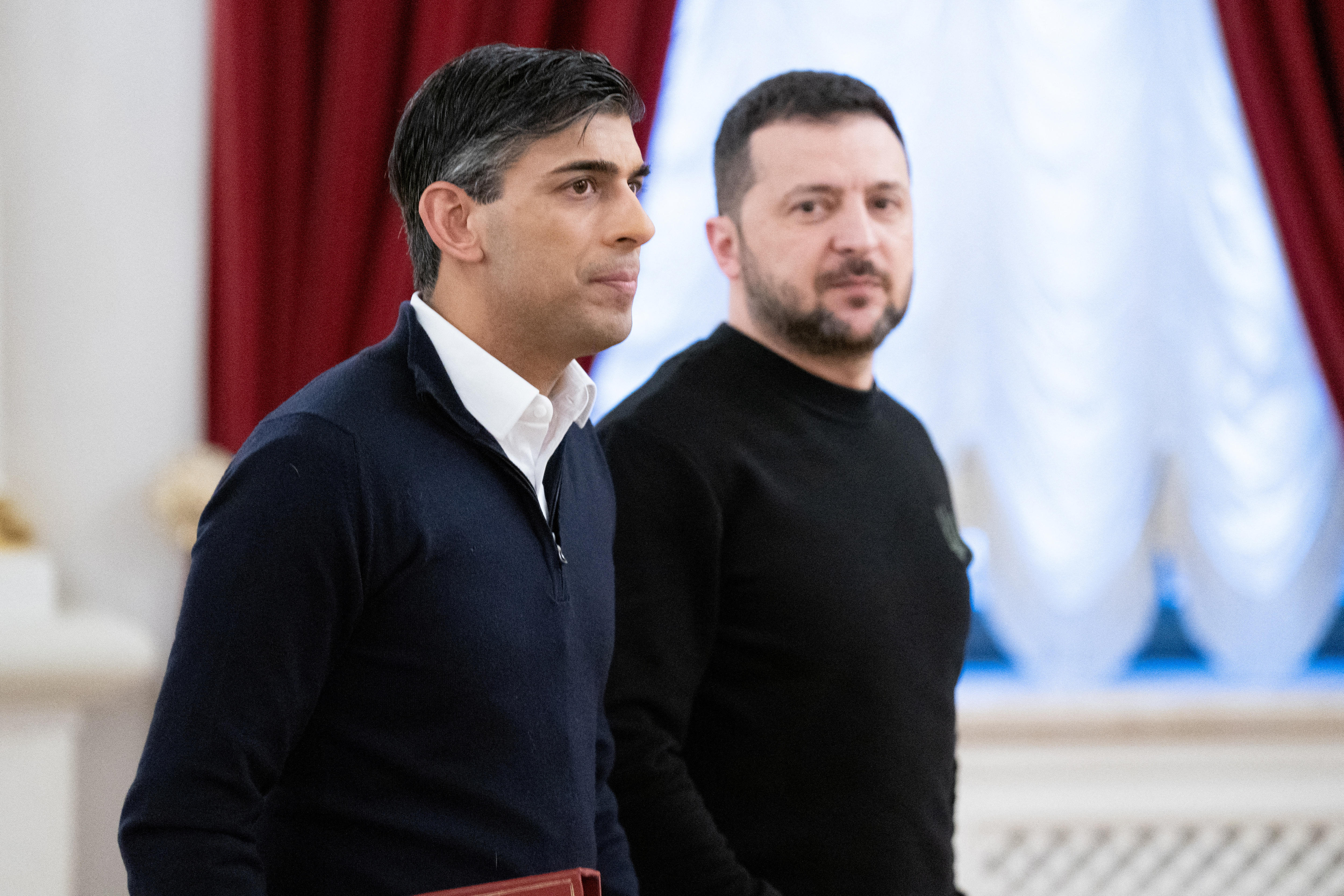 Side profiles of Rishi Sunak and Volodimir Zelenskyy behind him.