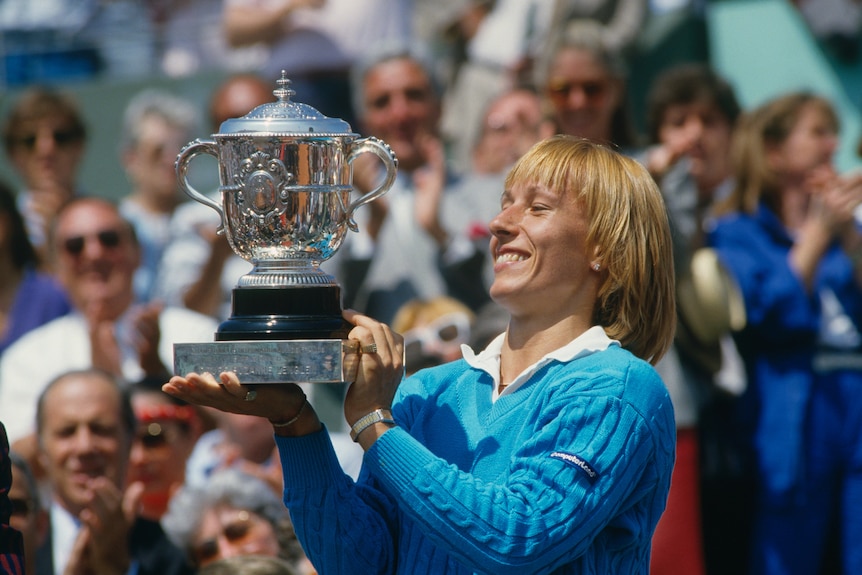 Martina Navratilova lifts the French Open trophy and smiles.