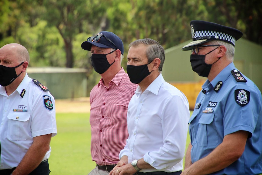 A group of men wearing masks standing together