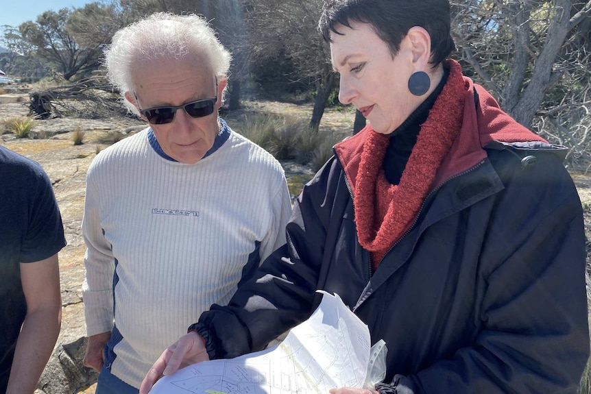 Robyn Moore showing a plan of a jetty proposal to a man.
