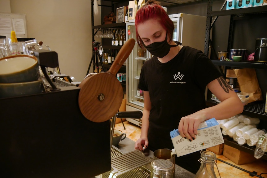 a barista pours a coffee