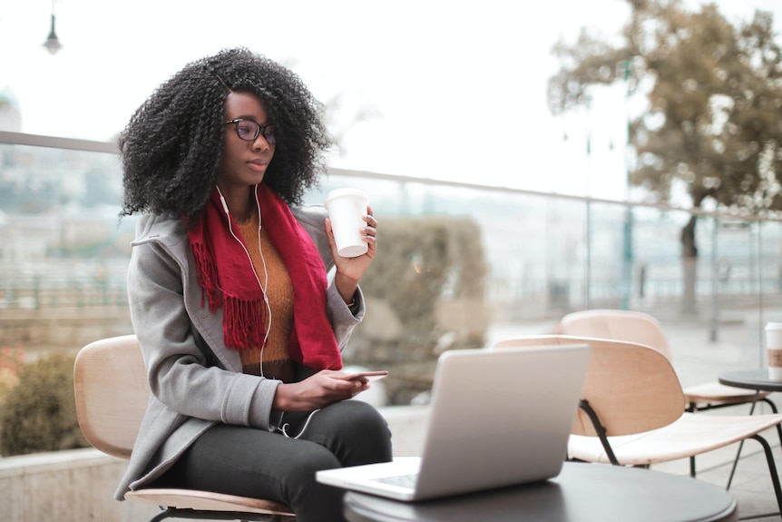 Woman sitting outside working on her laptop