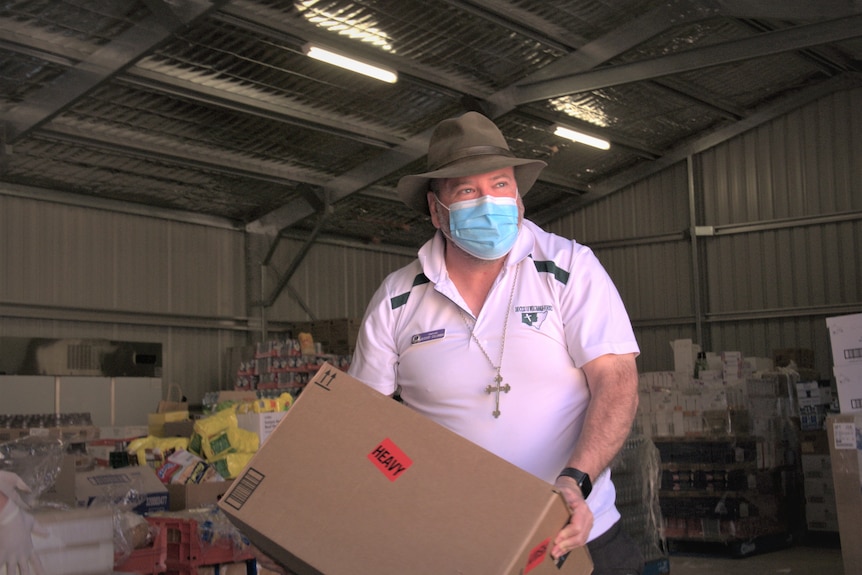Columba Macbeth-Green lifts a box at the Wilcannia food shelter. 