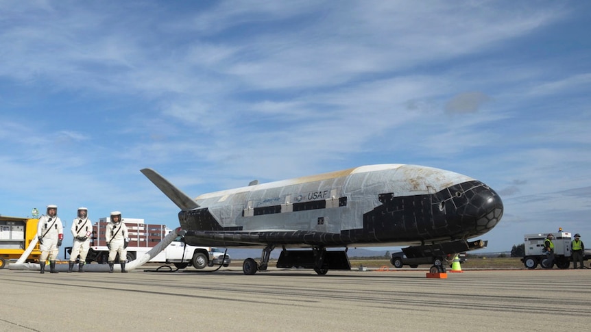 a picture of the space plane on a run way with space crew 