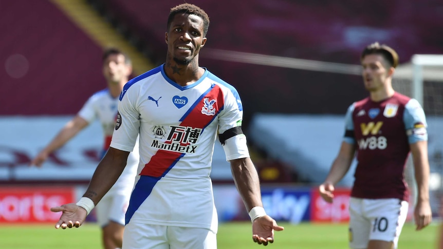 An upset Premier League footballer holds his hands out in question during a match.