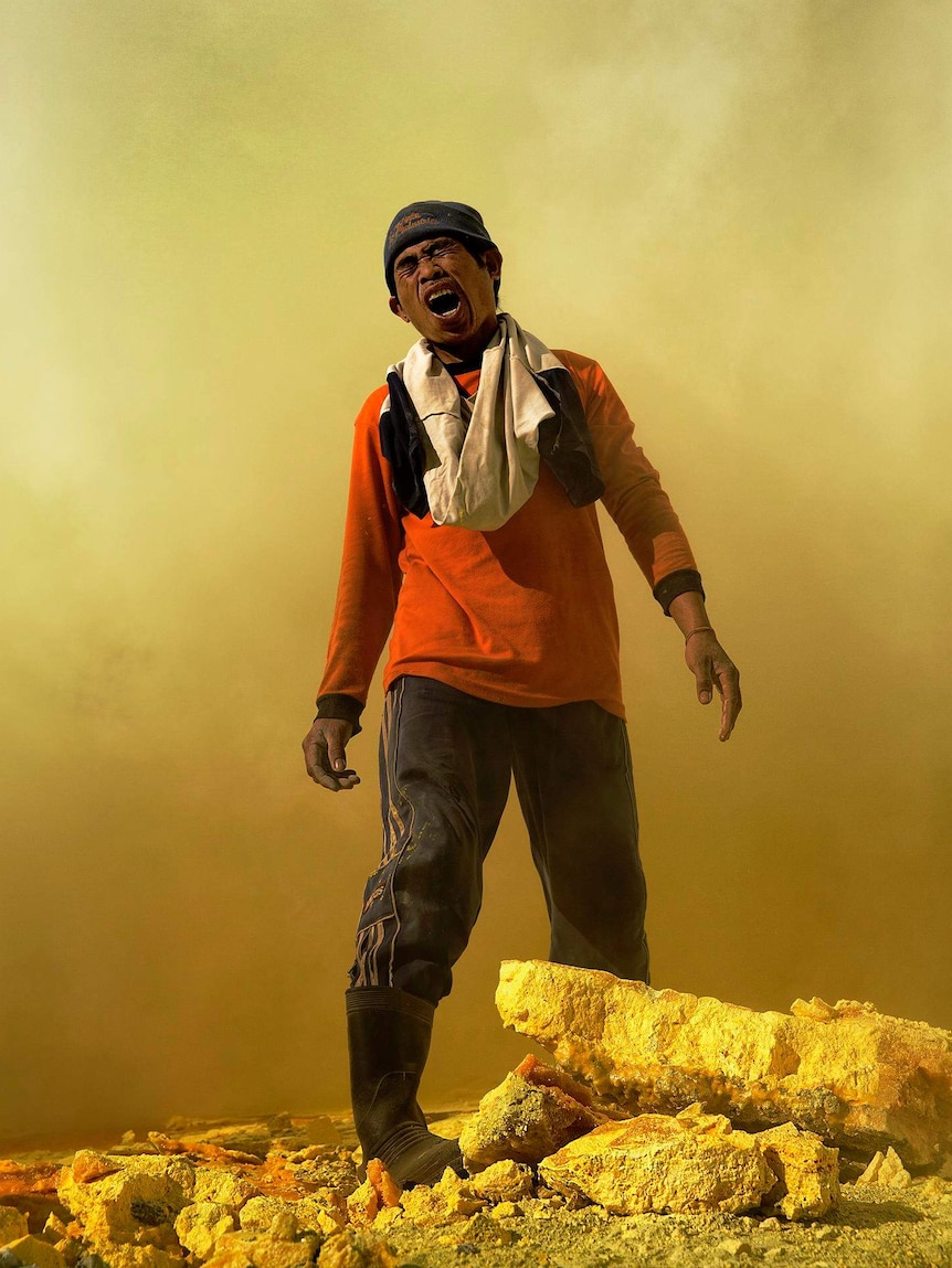 A sulphur miner screams in pain as he sucks in a lungful of toxic sulphur dioxide and hydrogen sulphide.