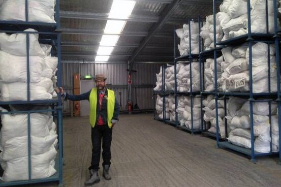St Vinnies warehouse manager Gary with the mountain of donated bags of clothing