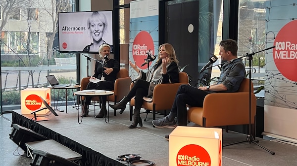 Two guests and a present sitting on armchairs and radio mikes at a broadcast in the ABC lobby.