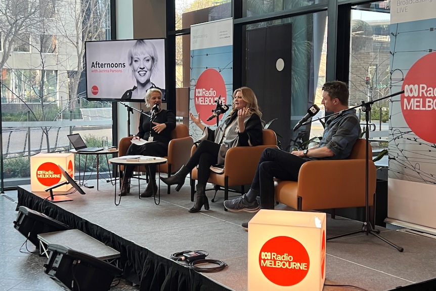 Two guests and a present sitting on armchairs and radio mikes at a broadcast in the ABC lobby.