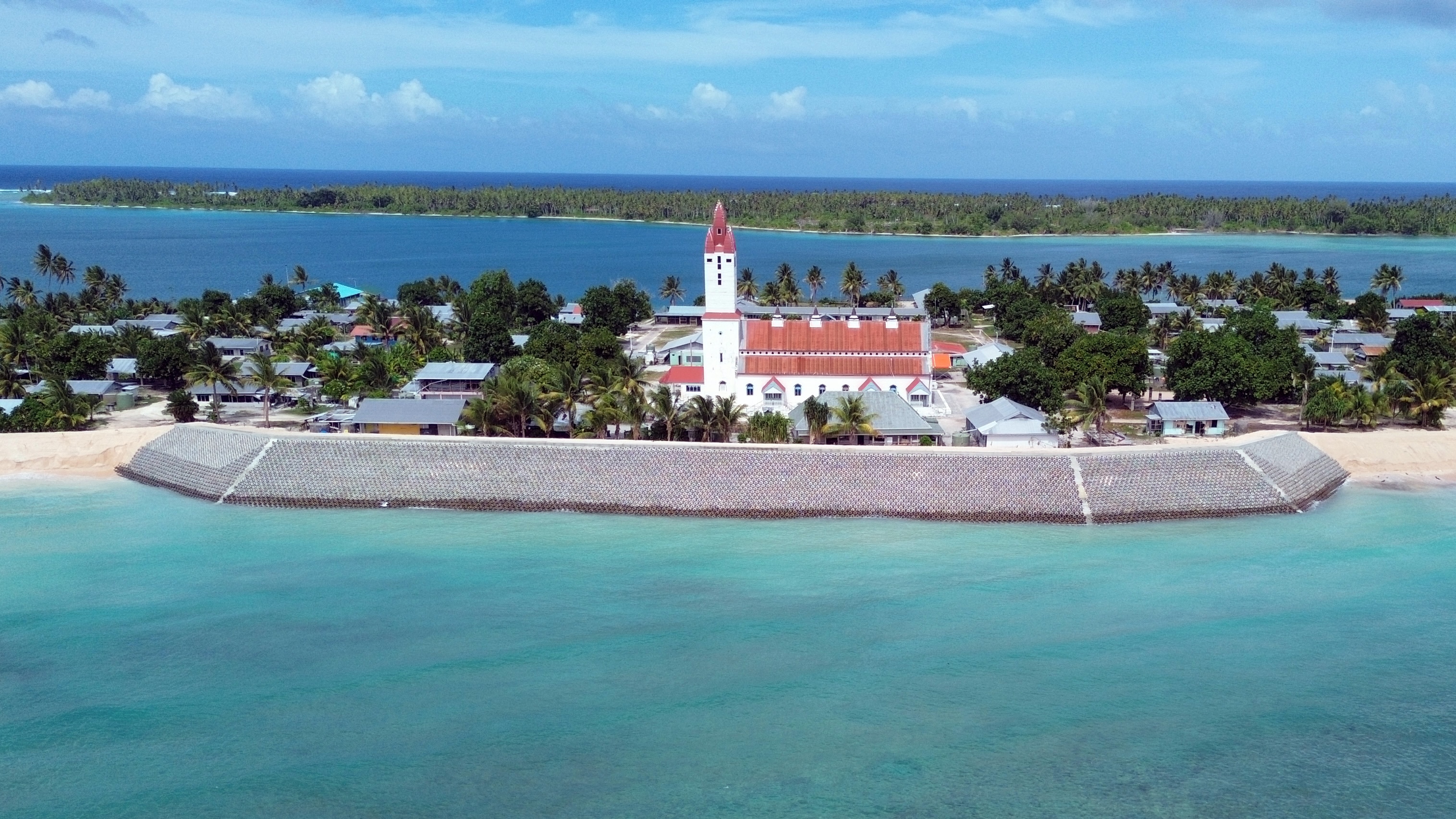 Protective sand barriers stand guard around the main church on the island of Nanumea.