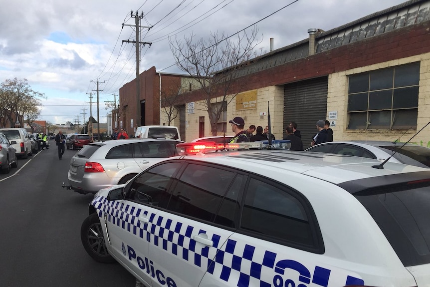 Police cars block part of a street in Oakleigh after suspected human remains are found.