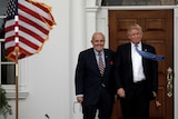 Donald Trump and Rudy Giuliani smiling next to an American flag.