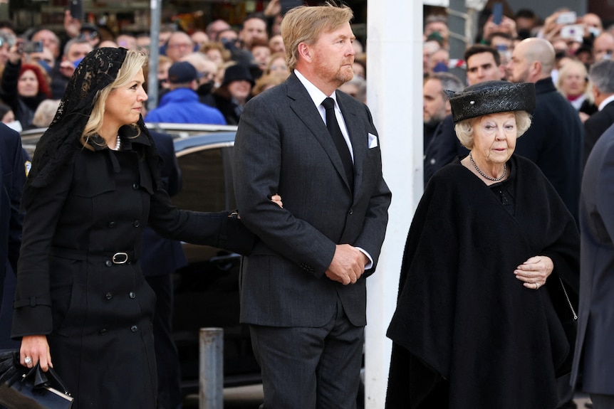 荷兰国王与马克西玛王后和前王后贝娅特丽克丝一起出席葬礼的照片。