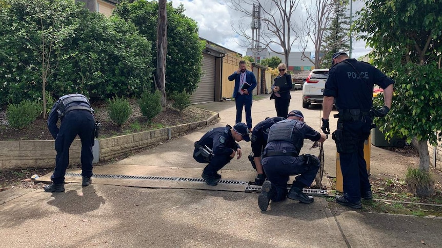 Police officers search outside a home