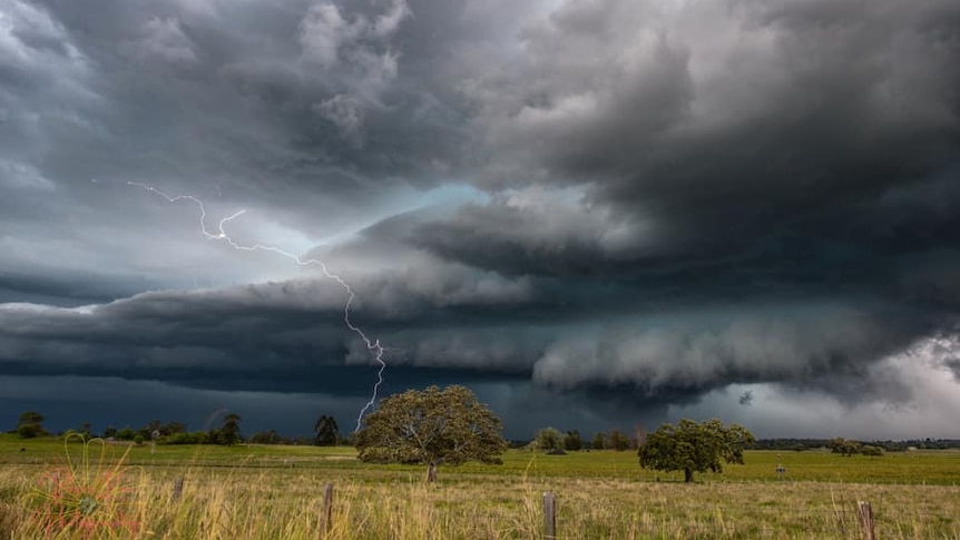 menacing storm cloud lets out lightning strike