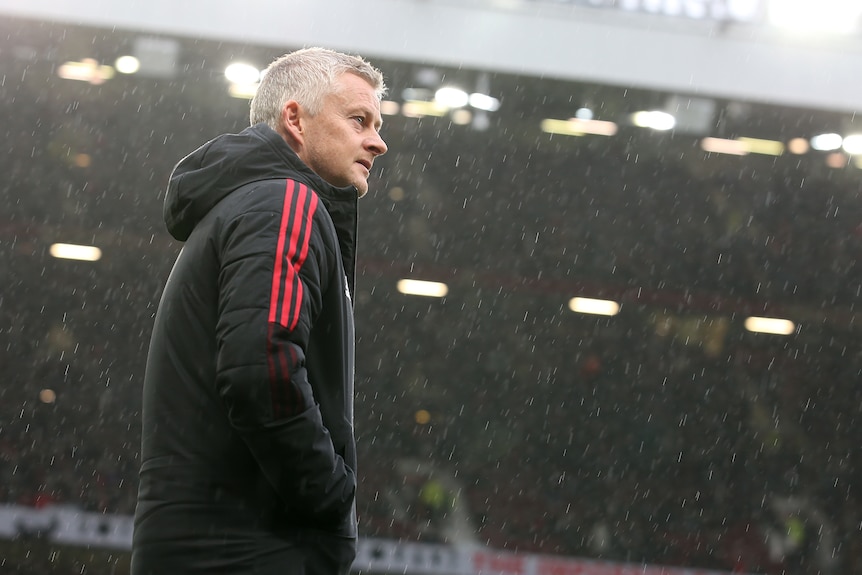Ole Gunnar Solskjaer stares out onto the pitch as rain falls