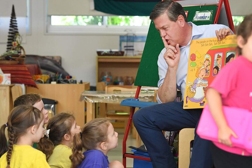 Opposition Leader Tim Nicholls reads a book to children during a visit to a preschool.