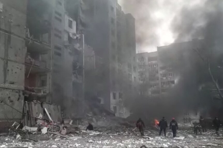 Workers clear the debris after the shelling attack on a apartment block.