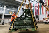 The 2.5m high four tonne Jade Buddha being lifted by a crane.