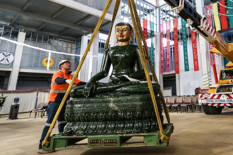 The 2.5m high four tonne Jade Buddha being lifted by a crane.