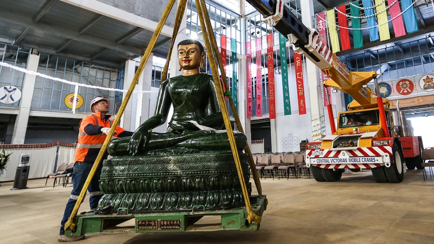 The 2.5m high four tonne Jade Buddha being lifted by a crane.