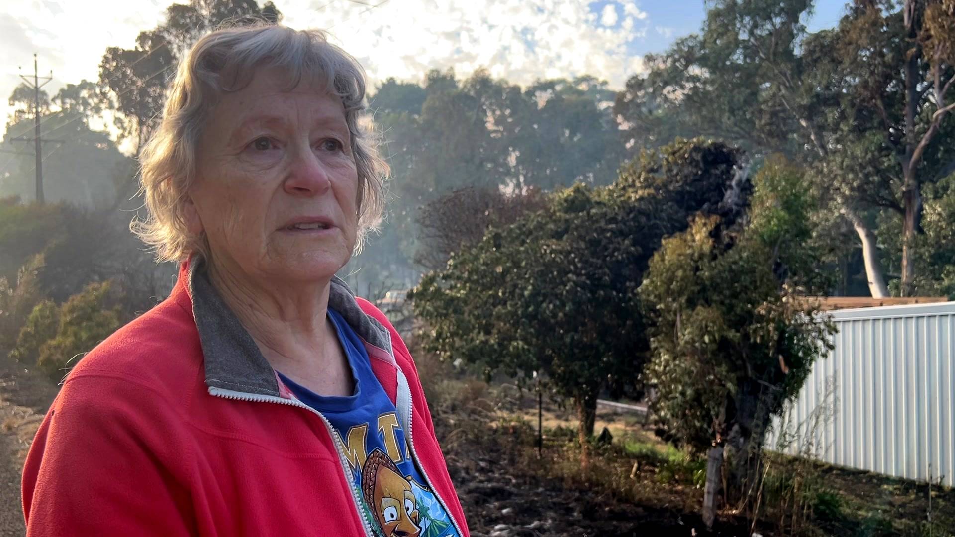 Un residente se encuentra cerca de un edificio destruido en la zona del incendio en Tooperang.