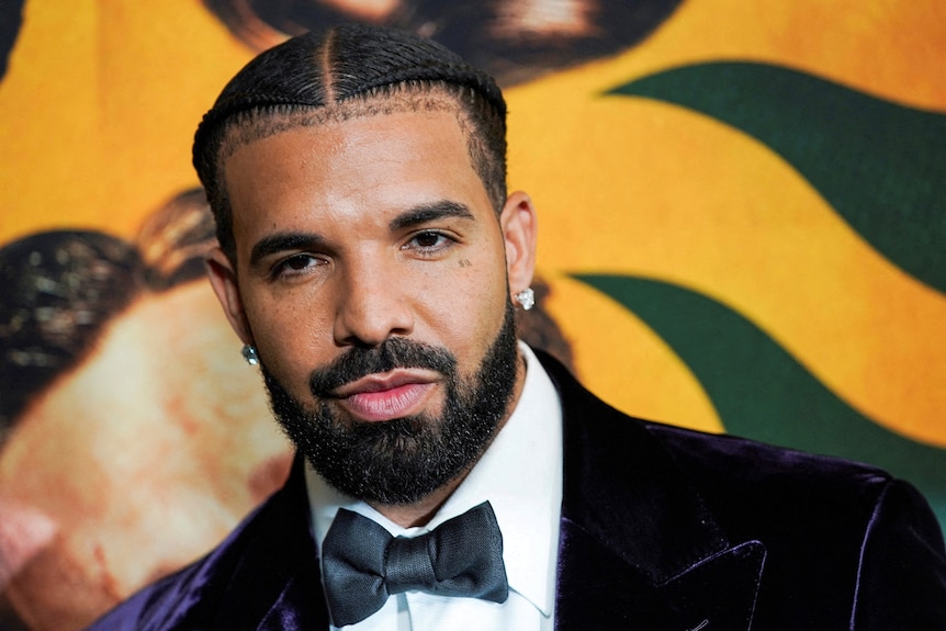 close up of drake on the red carpet in a purple velvet suit and black bowtie