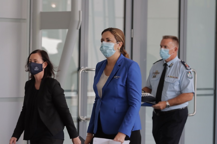 The Premier walks in to a press conference with the Health Minister and Vaccination Coordinator.