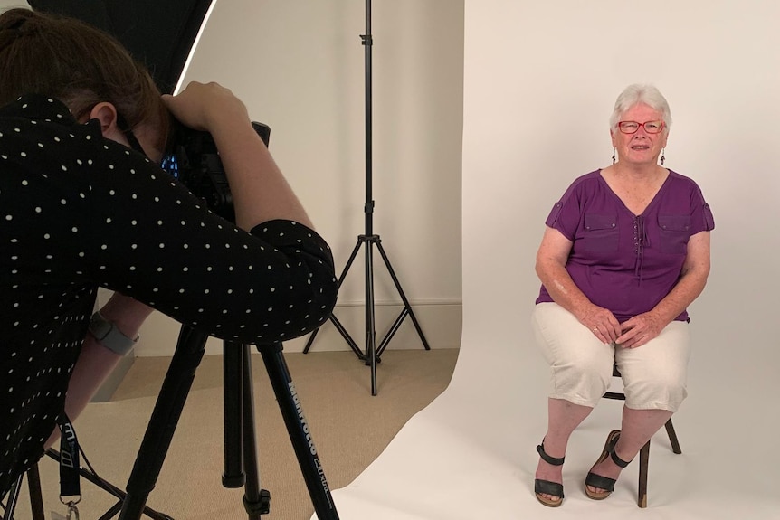 A woman has her photo taken by a photographer