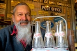 man with beard holding bottles 