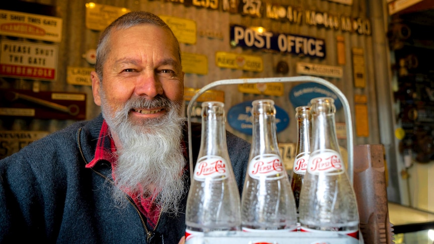man with beard holding bottles 