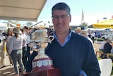 Breeza cotton and grain farmer John Hamparsum holding the Brownhill Cup at Agquip with the crowds in the background.