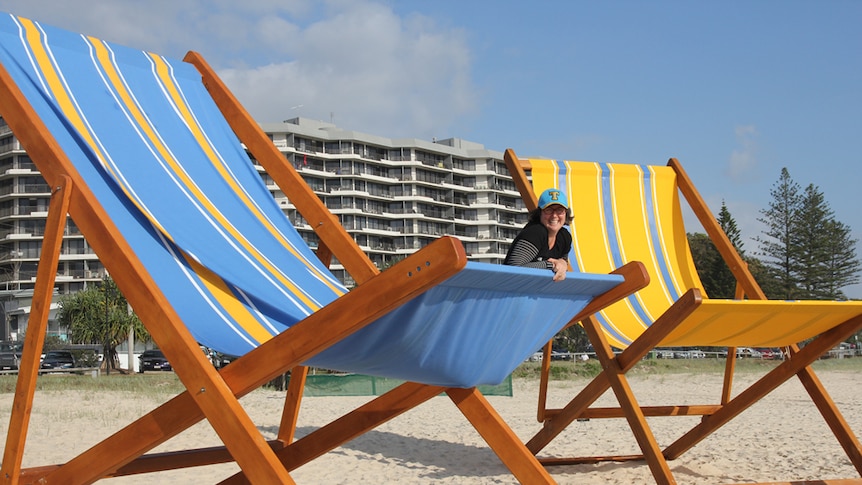 A woman sits in a giant deckchair at the Swell Sculpture Festival, Gold Coast