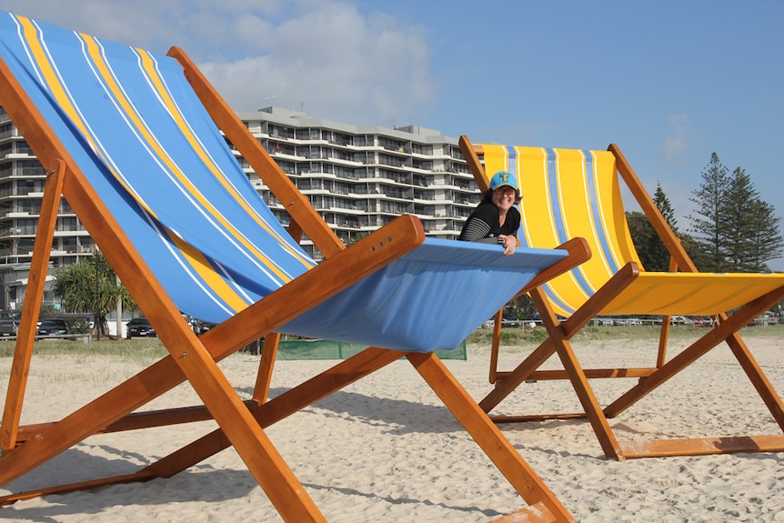 A woman sits in a giant deckchair at the Swell Sculpture Festival, Gold Coast