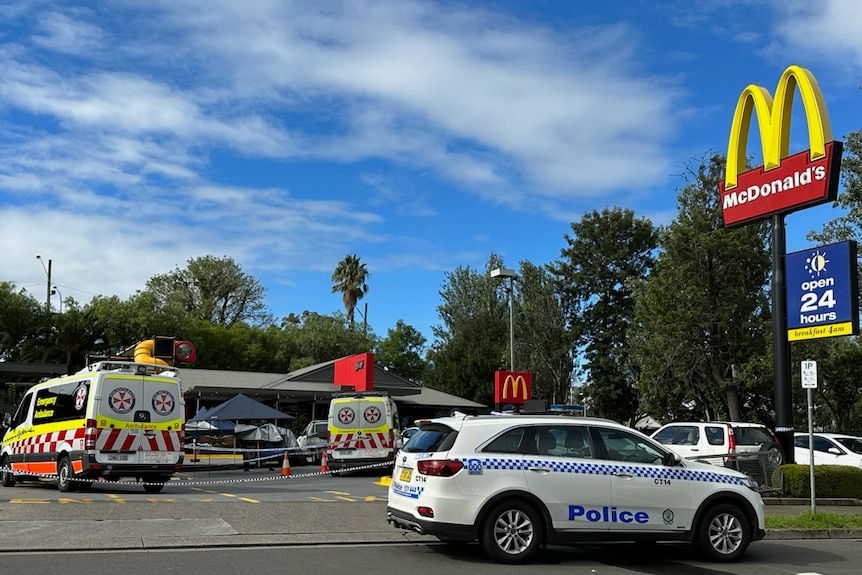 Ambulances and a police car parked outside a McDonalds restaurant