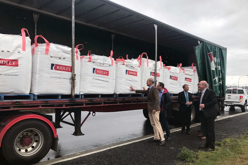 Guy Barnett, MP, and Adrian Lochland, General Manager of Ridley Corporation inspect bags of stock feed