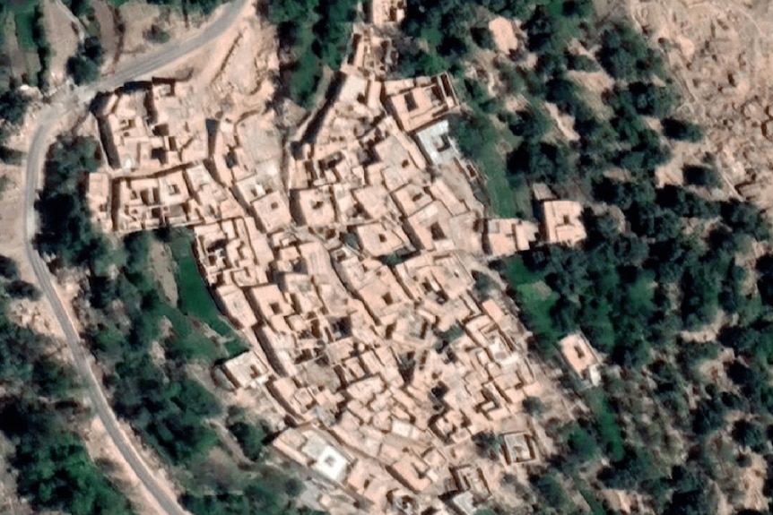A birds eye view shows a small village surrounded by forest