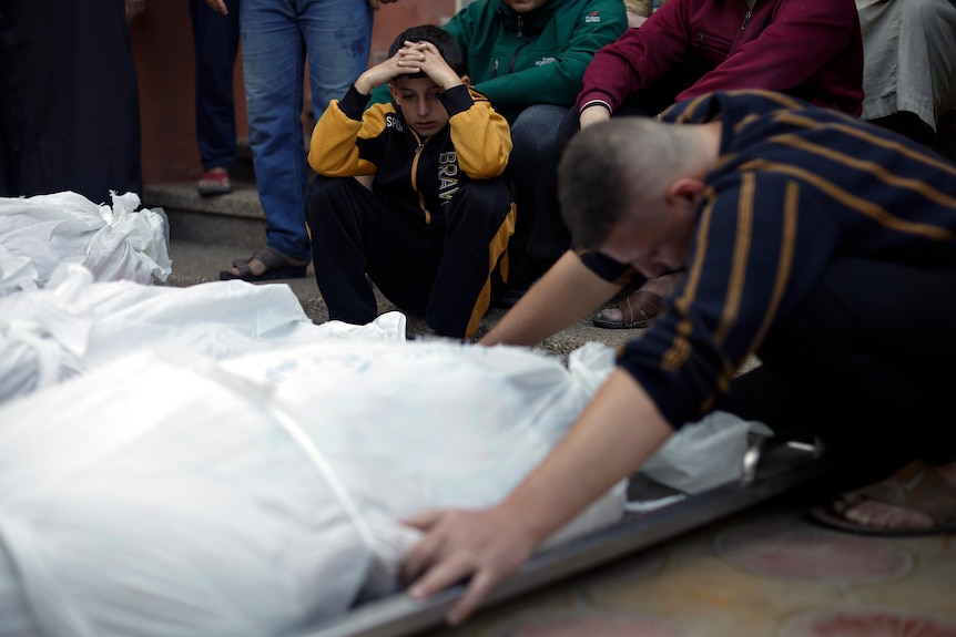 Palestinians mourn over the bodies of their relatives who were killed in Israeli bombardments.